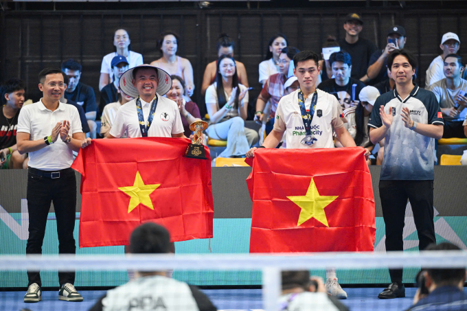 Hoàng Nam (trái) và Vinh Hiển cùng những lá cờ Việt Nam trên bục nhận giải, ở Cung điền kinh Mỹ Đình, Hà Nội hôm 5/4. Ảnh: Giang Huy