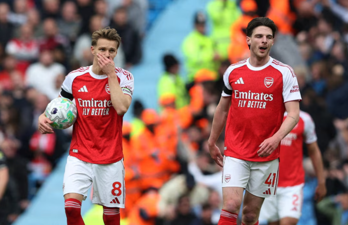 Martin Odegaard (trái) và Declan Rice thất vọng trong trận Arsenal thua Man City 1-2 ở vòng 33 Ngoại hạng Anh trên sân Etihad, Manchester, Anh ngày 19/4/2026. Ảnh: Reuters Martin Odegaard và Declan Rice thất vọng sau trận thua Man City