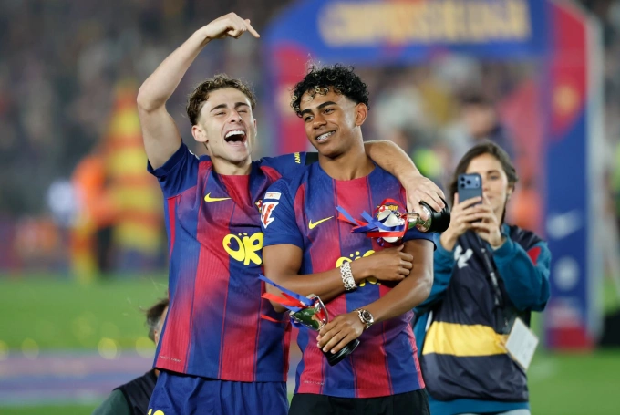 Yamal (phải) dù đang chấn thương nhưng đã có mặt trong lễ ăn mừng chức vô địch La Liga 2025-2026 của Barca. Ảnh: EFE