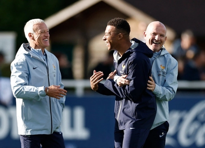 Mbappe cười đùa và trao đổi với HLV Deschamps (trái) và trợ lý Guy Stephan (phải) trong buổi tập của tuyển Pháp tại Clairefontaine ngày 1/9/2025. Ảnh: Reuters