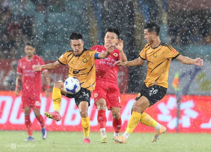 Cơn mưa lớn trên sân Hàng Đẫy khiến cầu thủ Công an Hà Nội và Thanh Hóa (áo vàng) bước vào trận thủy chiến. Ảnh: Hoàng Huynh Mưa lớn làm khó khán giả và cầu thủ trận Công an Hà Nội gặp Thanh Hóa