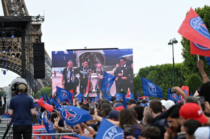 Người hâm mộ PSG cổ vũ trước màn hình lớn hiển thị hình ảnh HLV Luis Enrique cùng các cầu thủ khi đội bóng hạ cánh xuống Paris. CĐV PSG cổ vũ tại tháp Eiffel