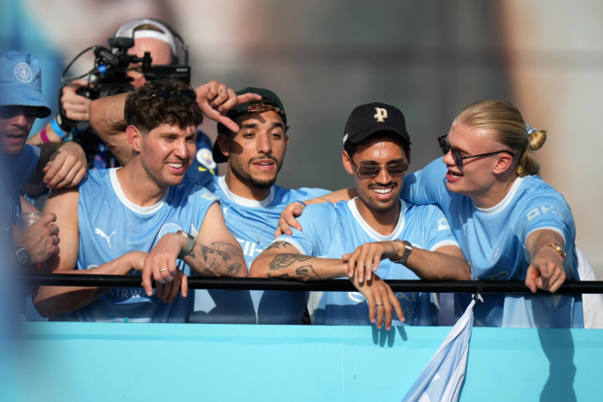 Erling Haaland cùng đồng đội diễu hành kỷ niệm thành tích của Man City tại Manchester Erling Haaland (phải) cùng các đồng đội trên xe buýt mui trần trong lễ diễu hành kỷ niệm thành tích của các đội nam và nữ Man City tại Manchester ngày 25/5/2026.