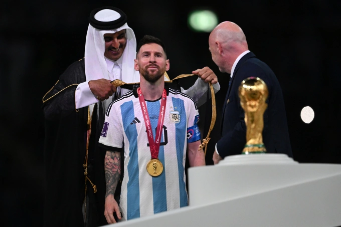 Tiểu vương Qatar (trái) khoác áo choàng Hồi giáo lên người cầu thủ Lionel Messi sau trận chung kết World Cup 2022 ngày 18/12. Ảnh: AFP