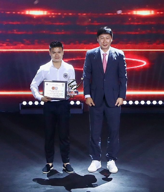 HLV Kim Sang-sik (phải) trao giải cầu thủ hay nhất V-League 2025-2026 cho tiền vệ Nguyễn Quang Hải của Công an Hà Nội tại Gala Awards V-League ở Hà Nội ngày 15/6/2026. Ảnh: VPF