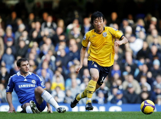 Tiền vệ West Brom Kim Do-heon (áo vàng) đi bóng qua hậu vệ Chelsea Branislav Ivanovic trong trận Ngoại hạng Anh trên sân Stamford Bridge, London ngày 26/12/2008. Ảnh: AFP
