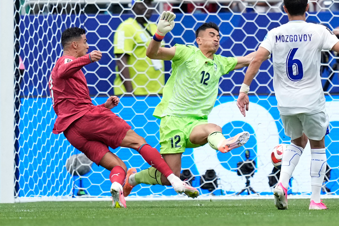 Cristiano Ronaldo va chạm với thủ môn trong nỗ lực dứt điểm Ronaldo tranh chấp với thủ môn Uzbekistan