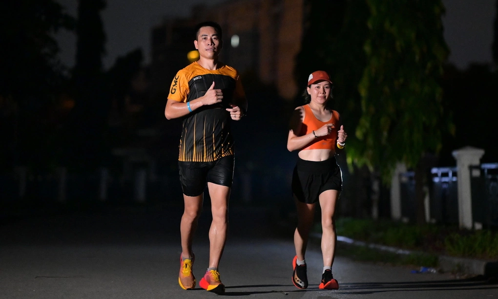 Nữ nunner Thu Hường (phải) chạy xuyên đêm trong sự kiện của CLB chạy Goldmark City, Phúc Diễn, Hà Nội ngày 1-2/8. Ảnh: GMC